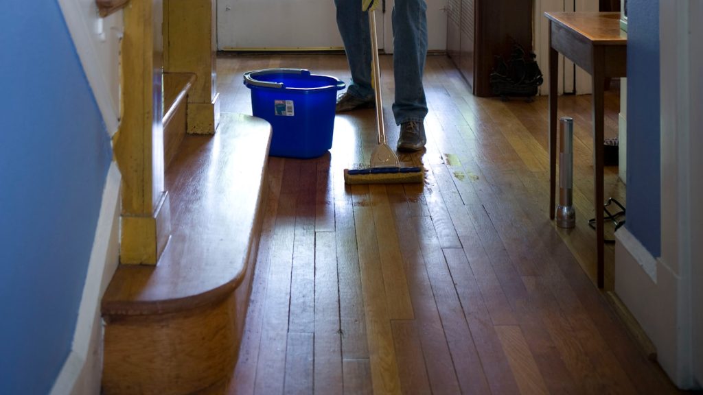 Preparing hardwood flooring in a vacation rental before guests arrive.