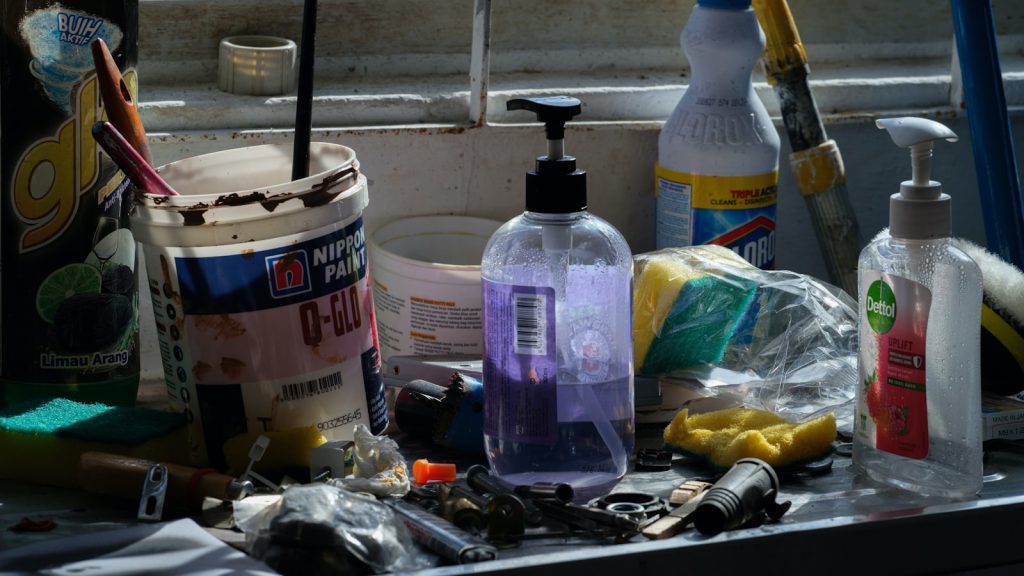 Assorted cleaning supplies and tools laid out on a kitchen counter.