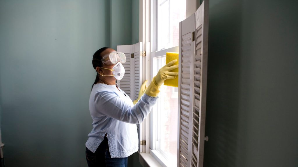 Cleaning the inside of a large window where fine desert dust collects.